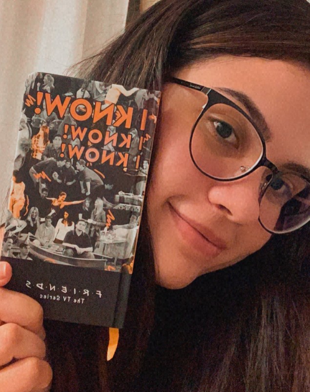 Pâmela Dayane sorrindo, segurando um caderno da série Friends